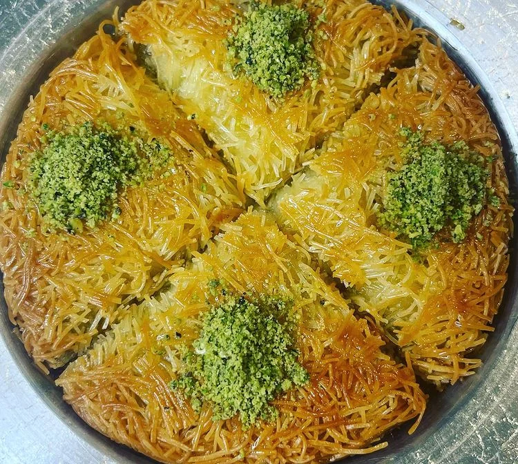 Kataifi: Golden shredded pastry wrapped around pistachio, finished with a bright green crown.